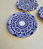 Three handcrafted blue and white Moroccan ceramic plates with intricate designs, suitable for wall decor or serving.