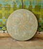 Elegant circular tile table adorned with a flower design, highlighting unique Moroccan craftsmanship in natural sage hues.