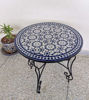 A stylish blue and white table featuring a potted plant, highlighting its mid-century Moroccan charm for versatile decor.