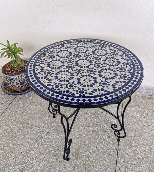 A stylish blue and white table featuring a potted plant, highlighting its mid-century Moroccan charm for versatile decor.