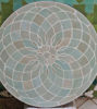 Detailed view of a circular sage green tile with a floral pattern, highlighting the craftsmanship of Moroccan Zellige tiles.