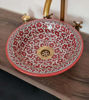 Handmade red and white ceramic washbasin with a gold faucet, featuring floral patterns, perfect for modern or rustic decor.