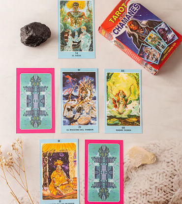 Tarot cards from the Shamans’ Tarot Deck are spread out on a table, showcasing Andean-inspired artwork and symbolism.