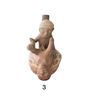 Small ceramic replica of a man and woman seated on a wooden box, showcasing Moche culture's erotic pottery tradition.