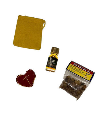 A small bag, heart, perfume bottle, and herbs from the Embrujo de Amor Love Scent Kit for love and attraction rituals.