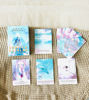Starseed Oracle Cards in Spanish laid out on a colorful blanket, showcasing their intricate designs for spiritual guidance.