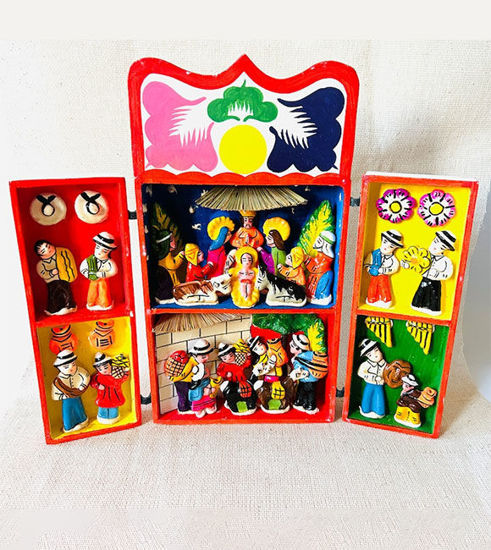 A box containing a vibrant handmade Peruvian nativity scene, featuring the Holy Family in a beautifully painted retablo.