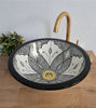 Handmade Moroccan ceramic sink in black and white with detailed patterns, paired with a gold faucet for a stylish touch.