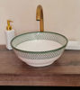 Minimalist white and green bowl with a fish scales pattern sits on a wooden counter, highlighting its handcrafted elegance.