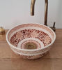 Brown and white Moroccan ceramic sink with a gold faucet, showcasing intricate patterns and a Mediterranean design.