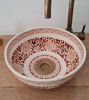 Hand-painted Moroccan ceramic sink in brown and white, complemented by a gold faucet, perfect for a Mediterranean-style bathroom.