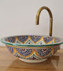 Vibrant ceramic sink featuring unique Moroccan designs and a brass faucet, perfect for adding charm to any bathroom.