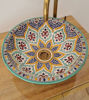 Handmade Moroccan ceramic washbasin with colorful patterns and a brass faucet, ideal for a stylish bathroom or kitchen.