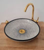 Black and white ceramic sink with a gold faucet, featuring a unique fish scale design, ideal for modern and antique bathrooms.