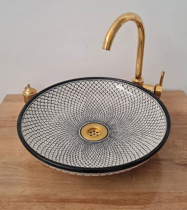 Black and white ceramic sink with a gold faucet, featuring a unique fish scale design, ideal for modern and antique bathrooms.