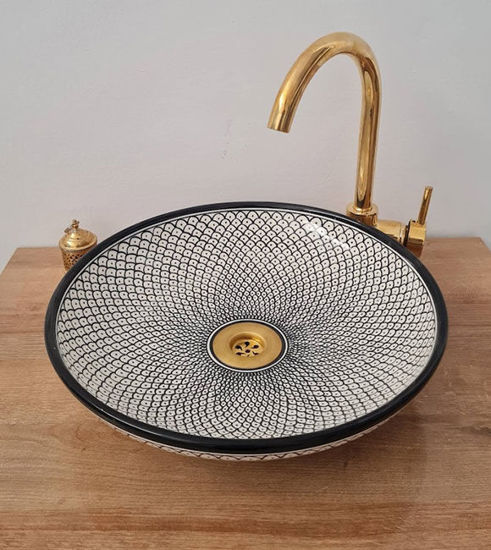 Black and white ceramic sink with a gold faucet, featuring a unique fish scale design, ideal for modern and antique bathrooms.