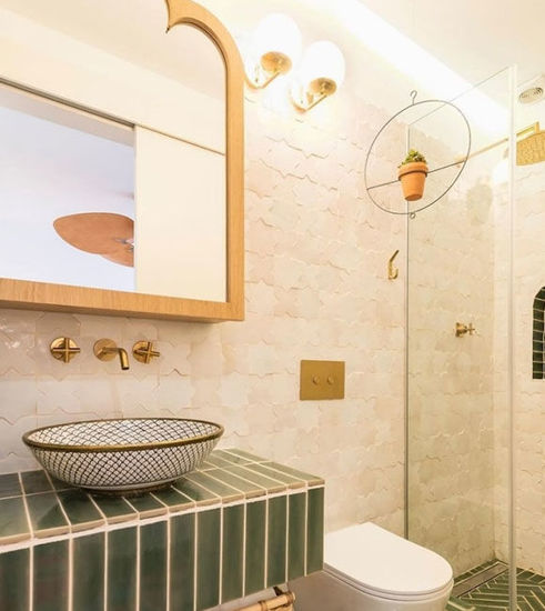 A bathroom featuring green tiles and a matching green sink, creating a cohesive and vibrant aesthetic.