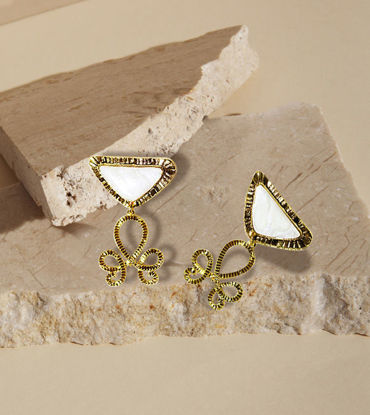 Two gold-tone earrings featuring white inverted triangle gemstones, showcasing intricate labyrinth-style metal detailing.