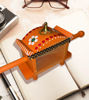 Vibrant orange and white wooden chariot toy adorned with flowers, representing traditional Channapatna art and craftsmanship.