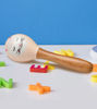 A cat-faced wooden rattle toy sits next to vibrant toy cars, showcasing charming, non-toxic play items for young children.