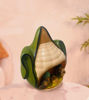 Handmade terracotta ornament featuring a corn cob with a green leaf, representing a unique Peruvian Nativity scene.