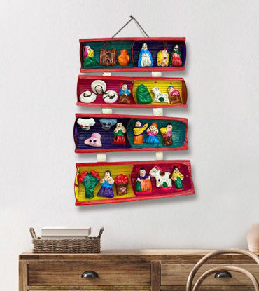 A shelf displaying a variety of toys, including a colorful handmade Cane Retablo Nativity Scene crafted from clay.