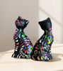 A pair of ceramic cat figurines, handcrafted in Peru, sitting on a table, adding cultural charm and whimsy.