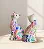 Two colorful Peruvian ceramic cats on a table, each uniquely hand-painted, reflecting traditional folk art craftsmanship.