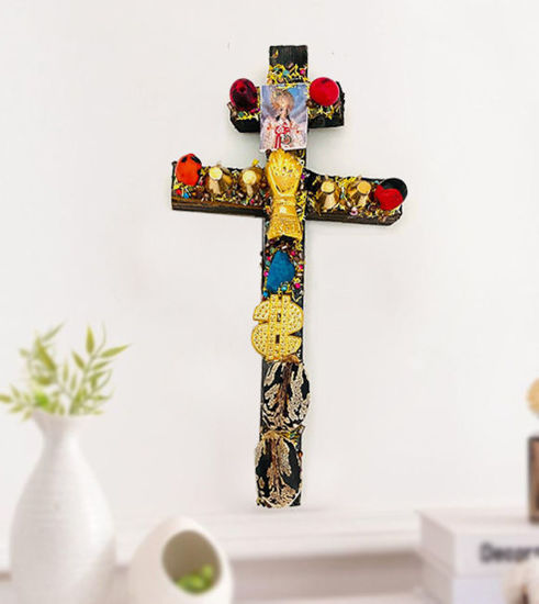 A Caravaca Cross made of sacred Arbol de la Chonta wood displayed on a shelf, symbolizing protection and prosperity.