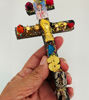 A unique Caravaca Cross crafted from sacred wood, showcased, known for its protective and prosperous qualities.