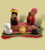 A table draped with cloth displays a unique, handmade nativity scene of the Holy Family, showcasing Peruvian artisan techniques.