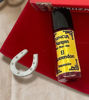 A bottle of El Querendon oil and a horseshoe, showcasing handmade materials for love and protection in spiritual practices.