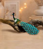 Colorful peacock figurine with a rhinestone tail on a white background, serving as a decorative trinket box for small treasures.