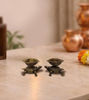 Two handcrafted brass tortoise diyas with ornate oil bowls, resting on a white surface, ideal for puja and decor.